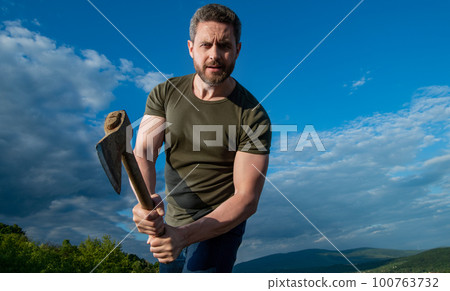 man threaten with axe. aggressive man hold ax. brutal man on sky background man threaten with axe. aggressive man hold ax. brutal man on sky background 100763732