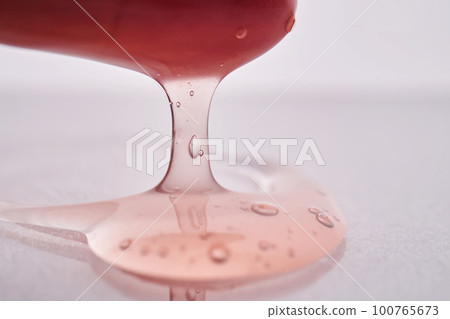 The texture of a pink viscous cosmetic product. 100765673