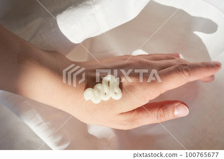 Photo of the texture of a moisturizing cream on the hand. Photo of the texture of a moisturizing cream on the hand. 100765677