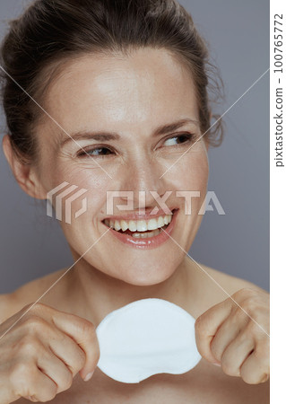 happy young woman with cotton pad on blue 100765772