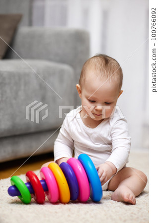 Cute baby girl playing with colorful toy pyramid Cute baby girl playing with colorful toy pyramid 100766092