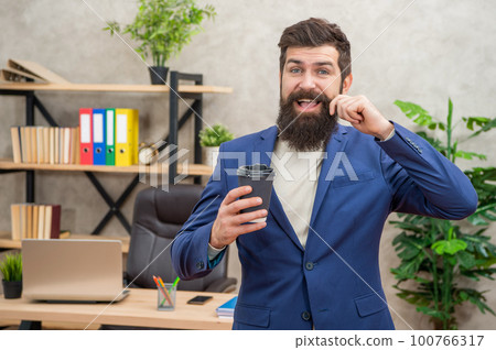glad brutal ceo in suit has lunch break with takeaway coffee cup at the office, morning coffee. 100766317
