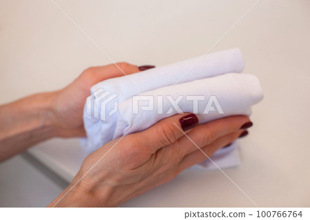 A woman folds her clothes. Mari Kondo system of vertical storage. A woman folds her clothes. Mari Kondo system of vertical storage. 100766764