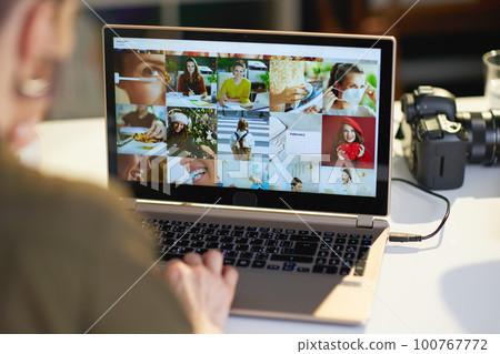 Closeup on female photographer with laptop viewing photos Closeup on female photographer with laptop viewing photos 100767772