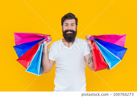 studio shot of happy shopaholic or shopper. man at shop with bags. shopper man with beard. 100768273
