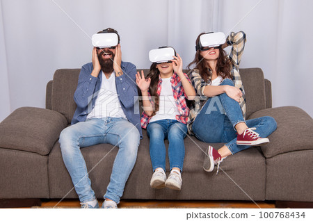 virtual reality family. happy parents with girl use modern technology. mom dad and daughter 100768434