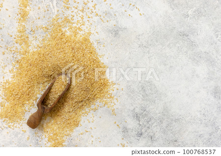 Wooden scoop of Dry uncooked bulgur wheat grain top view, copy space. Healthy food 100768537