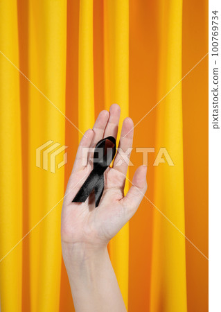 Woman holds black ribbon. Skin Cancer Awareness Month Concept. Health care 100769734