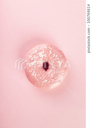 Doughnut in pink glaze and coconut sprinkle on pink background. Top view 100769814