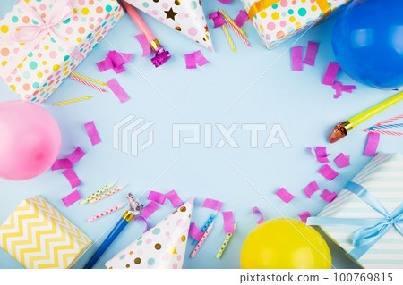 Birthday party attributes. Colorful balls, confetti, gifts, candles for cake. Blue background. Top view. Copy space Birthday party attributes. Colorful balls, confetti, gifts, candles for cake. Blue background. Top view. Copy space 100769815