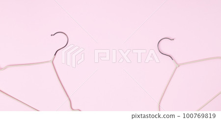 Creative flat lay hangers pastel pink background. Sale discount store promo shopping concept. Top view. Copy space 100769819