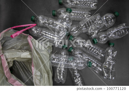 Recycling and ecology concept. Sorting household waste captured from above, flat lay. Grey concrete background empty plastic bottles Recycling and ecology concept. Sorting household waste captured from above, flat lay. Grey concrete background empty plastic bottles 100771120