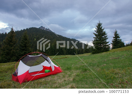 Open inner tent body without rainfly, on mountain col in grass in the morning. On background Velky Rozsutec. Mala Fatra mountains, Slovakia. 100771153