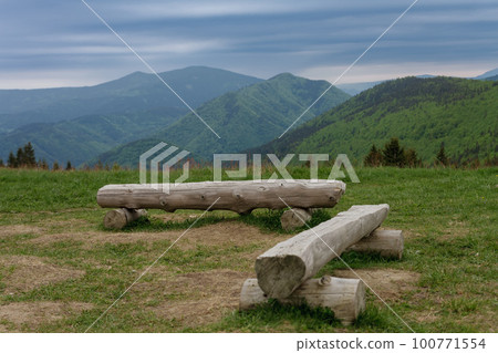 Wooden benches in mountain pass Medziholie in national park Mala Fatra, natural reserve Velky Rozsutec, Slovakia, spring cloudy day. 100771554
