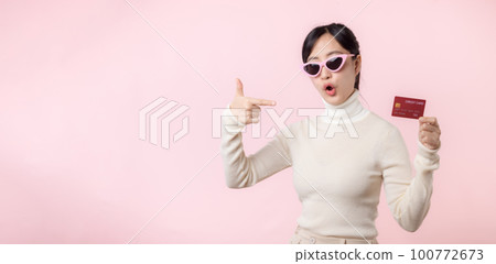 Fascinating fun joyful young woman of Asian ethnicity 20s years old with wear sunglasses wears white shirt hold in hand credit bank card isolated on plain pastel light pink background studio portrait. Fascinating fun joyful young woman of Asian ethnicity 20s years old with wear sunglasses wears white shirt hold in hand credit bank card isolated on plain pastel light pink background studio portrait. 100772673