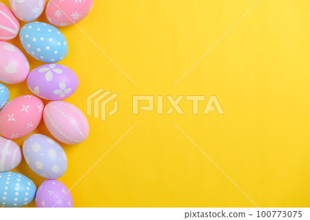 Happy easter holiday celebration concept. Group of painted colourful eggs decoration on a yellow background. Seasonal religion tradition design. Top view, flat lay, copy space. 100773075