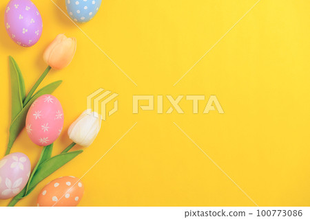 Happy Easter holiday greeting card design concept. Colorful Easter Eggs and spring flowers on yellow background. Flat lay, top view, copy space. Happy Easter holiday greeting card design concept. Colorful Easter Eggs and spring flowers on yellow background. Flat lay, top view, copy space. 100773086