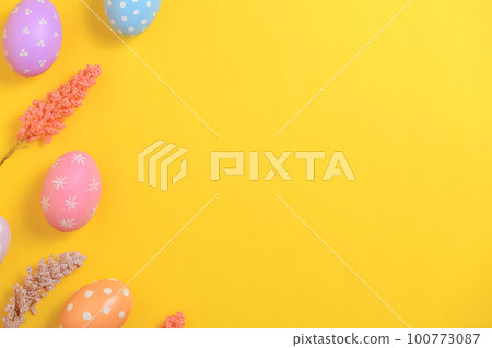 Happy Easter holiday greeting card design concept. Colorful Easter Eggs and spring flowers on yellow background. Flat lay, top view, copy space. Happy Easter holiday greeting card design concept. Colorful Easter Eggs and spring flowers on yellow background. Flat lay, top view, copy space. 100773087