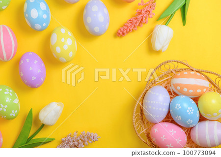 Happy Easter holiday greeting card design concept. Colorful Easter Eggs and spring flowers on yellow background. Flat lay, top view, copy space. Happy Easter holiday greeting card design concept. Colorful Easter Eggs and spring flowers on yellow background. Flat lay, top view, copy space. 100773094