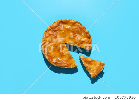 Phyllo cake top view on a blue table. Homemade spinach and cheese pie 100773936