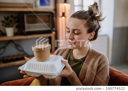 Young woman ordered lunch from the restaurant. 100774522