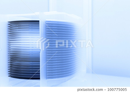 A lot of silicon wafers packed in a plastic storage box in the clean room of a semiconductor foundry ready for microchip production. A lot of silicon wafers packed in a plastic storage box in the clean room of a semiconductor foundry ready for microchip production. 100775005