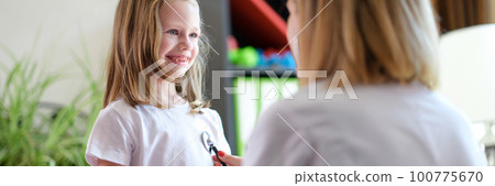 Pediatrician listens to lungs of little girl child with stethoscope 100775670