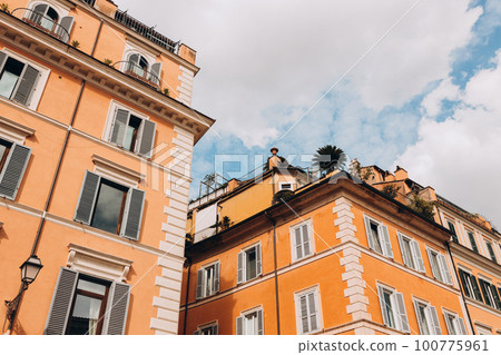 Architecture of Rome. A building with the characteristic ocher facade and green windows. Trastevere district 100775961