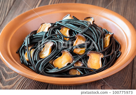 Black pasta with mushrooms 100775973