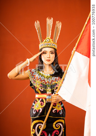 asian woman in king bibinge standing with salutation and holding the flag asian woman in king bibinge standing with salutation and holding the flag 100776938