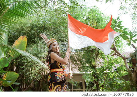 asian woman in king bibinge standing and waving the indonesian flag asian woman in king bibinge standing and waving the indonesian flag 100777086