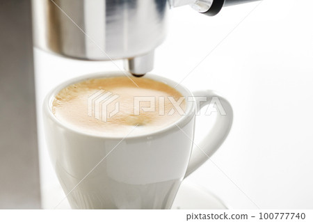 A cup of freshly brewed aromatic espresso on a white background. 100777740