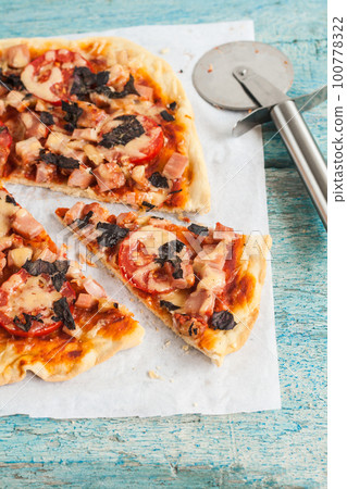 homemade pizza with salami, tomatoes and herbs homemade pizza with salami, tomatoes and herbs 100778322