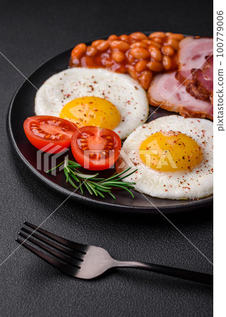 Delicious nutritious English breakfast with fried eggs and tomatoes 100779006