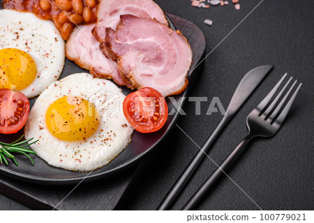 Delicious nutritious English breakfast with fried eggs and tomatoes Delicious nutritious English breakfast with fried eggs and tomatoes 100779021