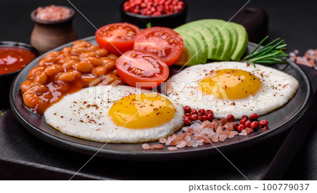 Delicious nutritious English breakfast with fried eggs, tomatoes and avocado Delicious nutritious English breakfast with fried eggs, tomatoes and avocado 100779037