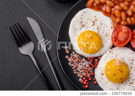 Delicious nutritious English breakfast with fried eggs, tomatoes and avocado Delicious nutritious English breakfast with fried eggs, tomatoes and avocado 100779039