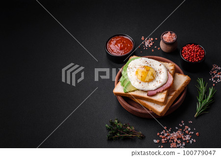 Delicious nutritious English breakfast with fried eggs, tomatoes and avocado 100779047