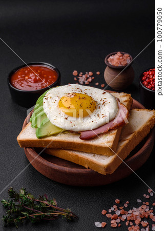 Delicious nutritious English breakfast with fried eggs, tomatoes and avocado Delicious nutritious English breakfast with fried eggs, tomatoes and avocado 100779050