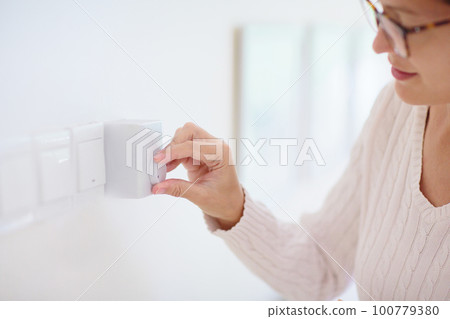 Woman adjusting thermostat. Central heating. Woman adjusting thermostat. Central heating. 100779380