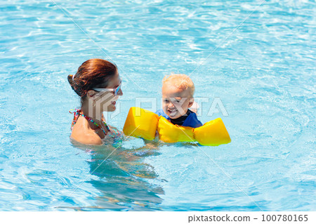 Mother and baby in swimming pool 100780165
