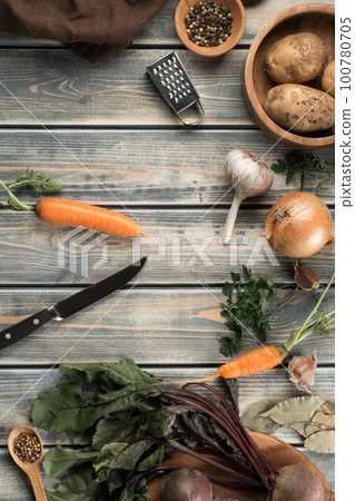 Knife for peeling carrots, flat lay. Mix of raw fresh organic vegetables on wooden table. Zero waste, eco concept. Knife for peeling carrots, flat lay. Mix of raw fresh organic vegetables on wooden table. Zero waste, eco concept. 100780705