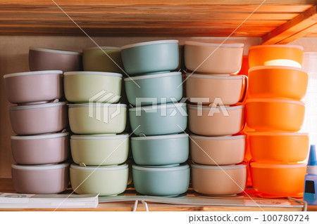 Multicolored silicone baby tableware stack, different forms of tureen on shelf of the store. Kid healthcare, First feed 100780724
