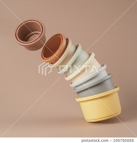 Set of colorful silicone bowls of different size for water game and play with sand stacked in column. Instagram use. 100780888