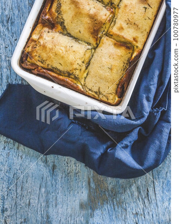 baked stuffed crepes on blue background and napkin top view baked stuffed crepes on blue background and napkin top view 100780977