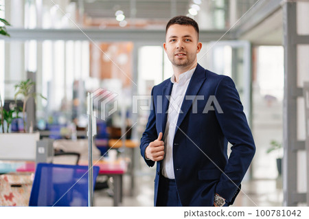 a man in a blue business suit in the coworking office.  100781042