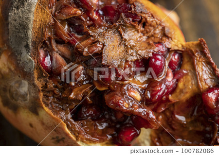 Rotten spoiled red ripe pomegranate on the board 100782086