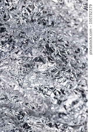 crumpled thin aluminum foil reflecting light 100782379