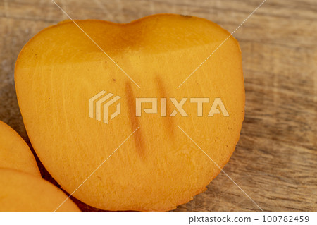 Half-ripe Orange persimmon, close up 100782459