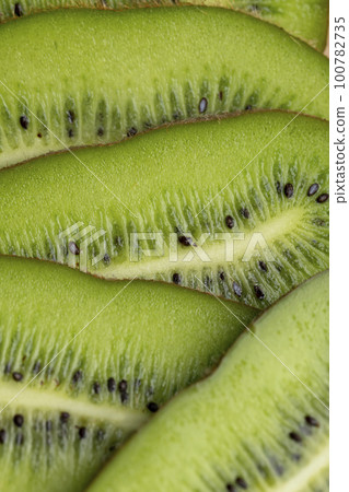 Sliced green ripe kiwi are lying on the table Sliced green ripe kiwi are lying on the table 100782735